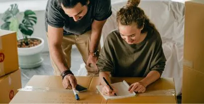 Couple moving home after buying packaging supplies such as cardboard boxes, marker pens and tape from local Eastbourne based business supplies company Fieldskill