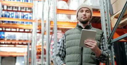 Image of a man from Fieldskill in a warehouse holding a tablet checking inventory levels of a local Eastbourne based business so they don't run out of workplace essentials again!
